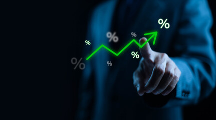 A businessman pointing at a glowing upward trend line with percentage symbols, representing...