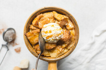 Overhead view of homemade bread pudding with vanilla ice cream, top view of fresh bread pudding with cream