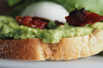 Delicious avocado toast topped with sun-dried tomatoes