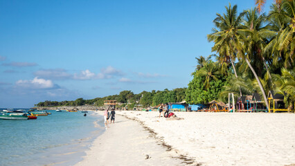 tropical beach with coconut palm trees and blue sky at Bara beach, Bira Bay