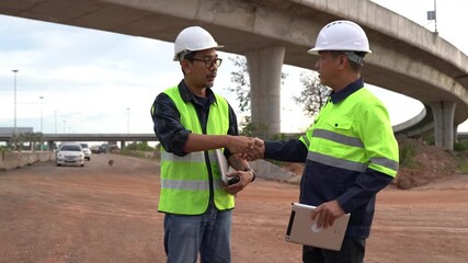 Construction workers discussing project details on road infrastructure site, engineering team in safety gear, collaborating on urban development project