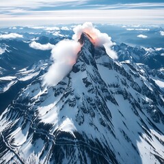 Majestic snow capped mountain peak with clouds and a winding road below under a bright sky