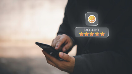 Businessman using smartphone to give five-star positive review with smiley face icon, Customers give 5-star reviews,symbolizing excellent customer feedback, and user satisfaction in digital service.