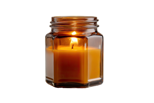 Lit candle in glass jar, amber wax and flame