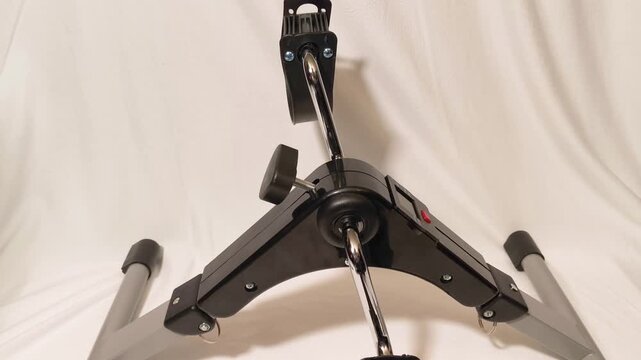 Portable exercise bike workout demonstrates simple, accessible fitness for seniors and rehabilitation patients to increase activity levels and maintain health with low impact movement