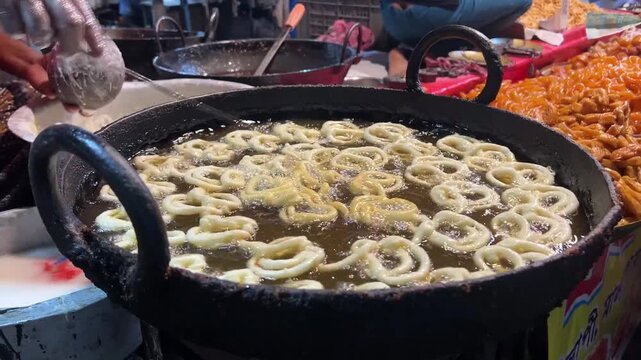 Golden jalebis spiral into hot oil, crisping in a Kolkata street shop on a winter morning.