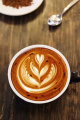 a cup of latte art coffee on wooden background                                       