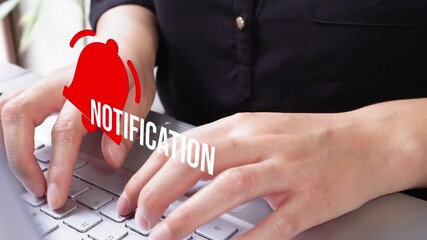 Close-up of a woman's hands working on her computer with a notification bell animation