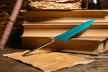 Old books with nib pen and paper sheet on wooden background