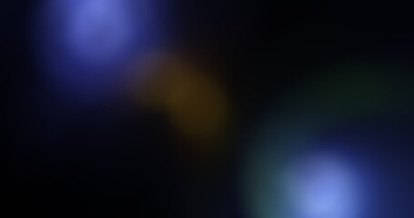 Abstract blue, yellow and green lens flares, bokeh, and light leaks on dark background, ideal for cinematic overlays, transitions, and blurred modern texture