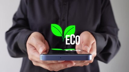 Eco-friendly options in technology. A woman holds a phone with a page bearing the word "Eco".