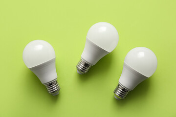 Modern light bulbs on green background