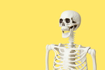 Scary human skeleton on yellow background