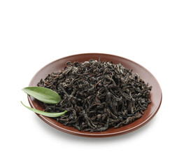 Plate with dry black tea and leaves on white background