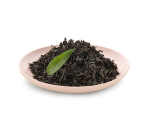Plate with dry black tea and leaf on white background