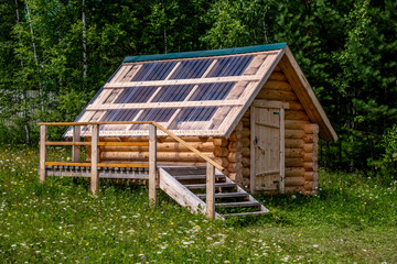 A small log cabin in the woods on a summer day.