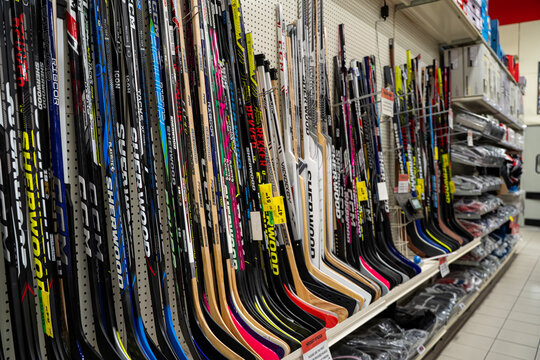 View of assorted hockey sticks displayed on sports store shelf. Brampton, Canada - November 16, 2025.