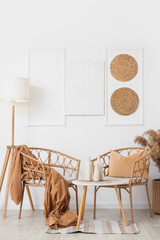 Interior of room with wicker armchairs, table and lamp