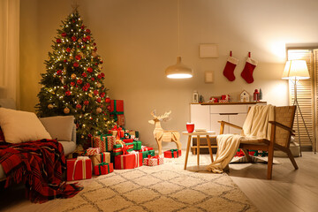Interior of festive room with sofa, armchair, coffee table, Christmas tree, many gift boxes and...