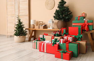 Interior of festive room with folding screen, Christmas trees, different many gift boxes and lantern on bench