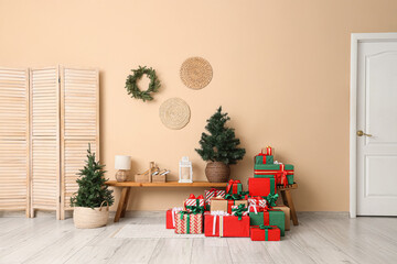 Interior of festive room with folding screen, Christmas trees, different many gift boxes and...