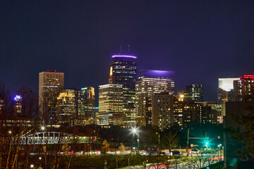 City skyline at night with bright lights from the buildings, traffic, and street lights