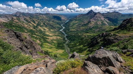 Scenic Mountain Valley with River and Lush Greenery Under Clouds
