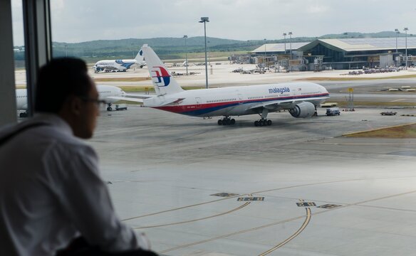 Silhouette of a man with Malaysia Airlines Boeing 777-200ER (9M-MRG)  in the background in KLIA, Sepang, Malaysia.