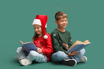 Naklejka premium Cute little children reading Christmas story on green background