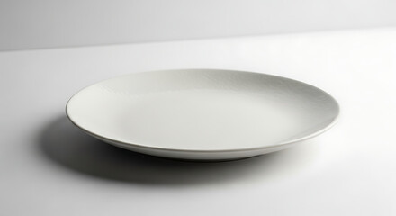 Elegant white ceramic plate on a clean white surface, perfect for food presentation.