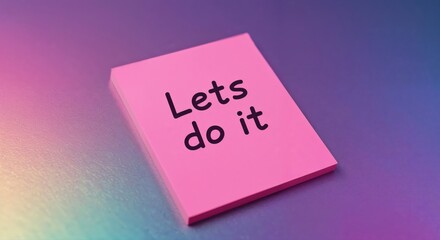 A Sticky Note of Inspiration: A vibrant pink sticky note, bearing the encouraging message Let's do it, rests on a textured, colorful surface, embodying motivation and productivity.