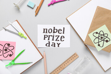 Paper with text NOBEL PRIZE DAY, books, drawn molecules and stationery on grey background