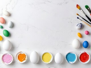 A collection of colorful Easter eggs, brushes, and paint pots are artfully arranged on a white marbled surface, ready for decorating.