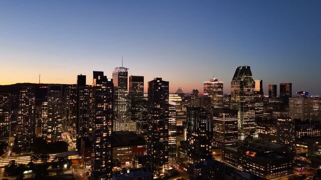 Montreal skyline at dusk, city lights reflecting over water in Grifintown and downtown. g.