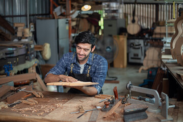 Luthier making guitar using traditional tools in workroom with manual tools