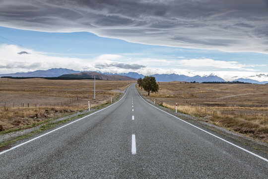 Road through desolate landscape in bad weather, New Zealand