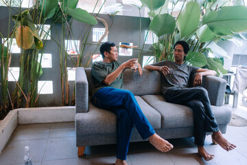 Two Men Relaxing on Sofa in Modern Indoor Setting