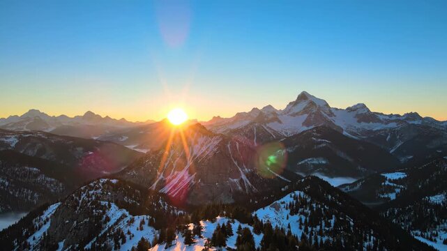 Sunrise over snowcapped mountain range.