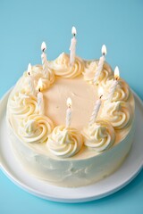 Delicious birthday cake with candles on a plate against a blue background for celebration