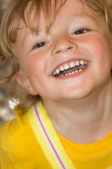 close-up of a surprised little blond boy in yellow clothes