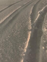 Snowy tire tracks at sunset on winter road in Russia