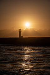 Fototapeta premium Felgueiras lighthouse on breakwater at mouth of Douro River in Porto, Portugal at sunset.