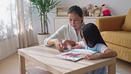 Asian family drawing picture together at home, colorful crayon art notebook, Mother and daughter help homework - Powered by Adobe