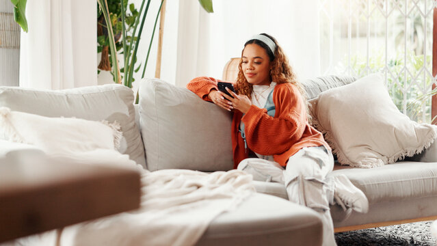 Relax, girl and scroll with phone on sofa for internet browsing, social media post or weekend break. Smile, woman and smartphone in home for streaming subscription, dating app profile or text message