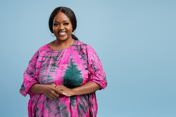 Body positive African American woman wearing colorful national Nigerian dress looking at camera