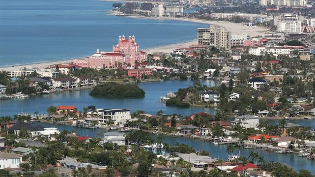 Sweeping aerial view of Saint Pete Beach looking north revealing waterfront homes with docks, The Don CeSar, and beachfront coastline vista with hotels and condos along Florida's scenic Gulf Coast.
