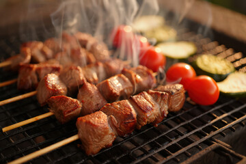 Delicious Grilled Meat Skewers with Fresh Vegetables on a Barbecue Grill, Perfect for a Summer Cookout, Featuring Juicy Beef, Ripe Tomatoes, and Zucchini Slices