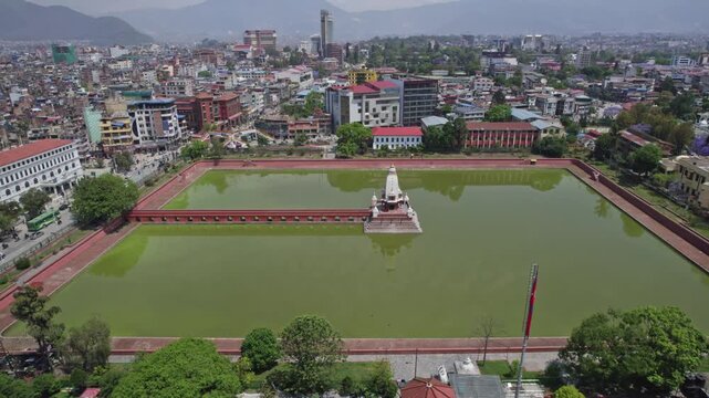 A serene drone view capturing ancient Rani Pokhari set against the wide Kathmandu Valley. The aerial shot showcases the landmark&rsquo;s heritage, calm waters, and the valley&rsquo;s timeless urban.