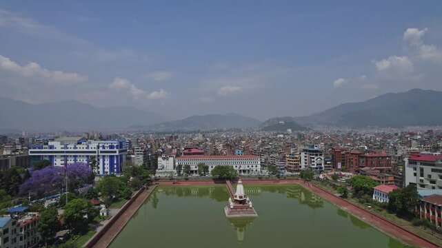 Drone view of Kathmandu Valley featuring Rani Pokhari, Ghantaghar, and blooming Jacaranda flowers, showcasing the valley&rsquo;s rich heritage, colors, and timeless urban charm.