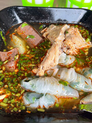 The closed up of Thai noodles. Asian noodle soup with beef meatball with fresh vegetable on wood table.